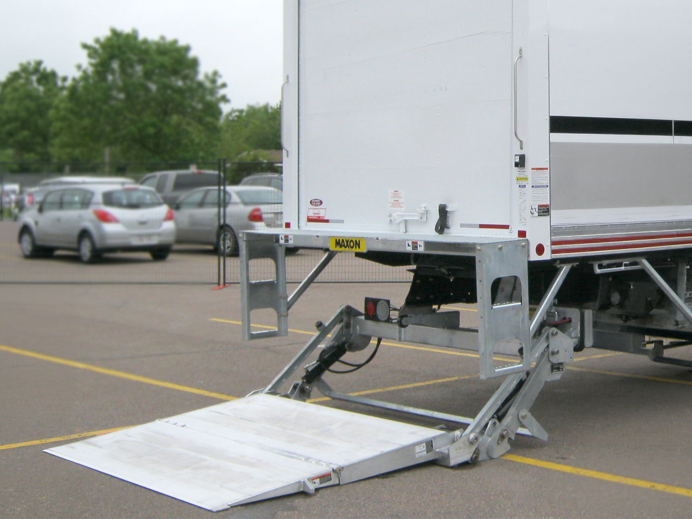 A Maxon liftgate lowered at the back of a box truck
