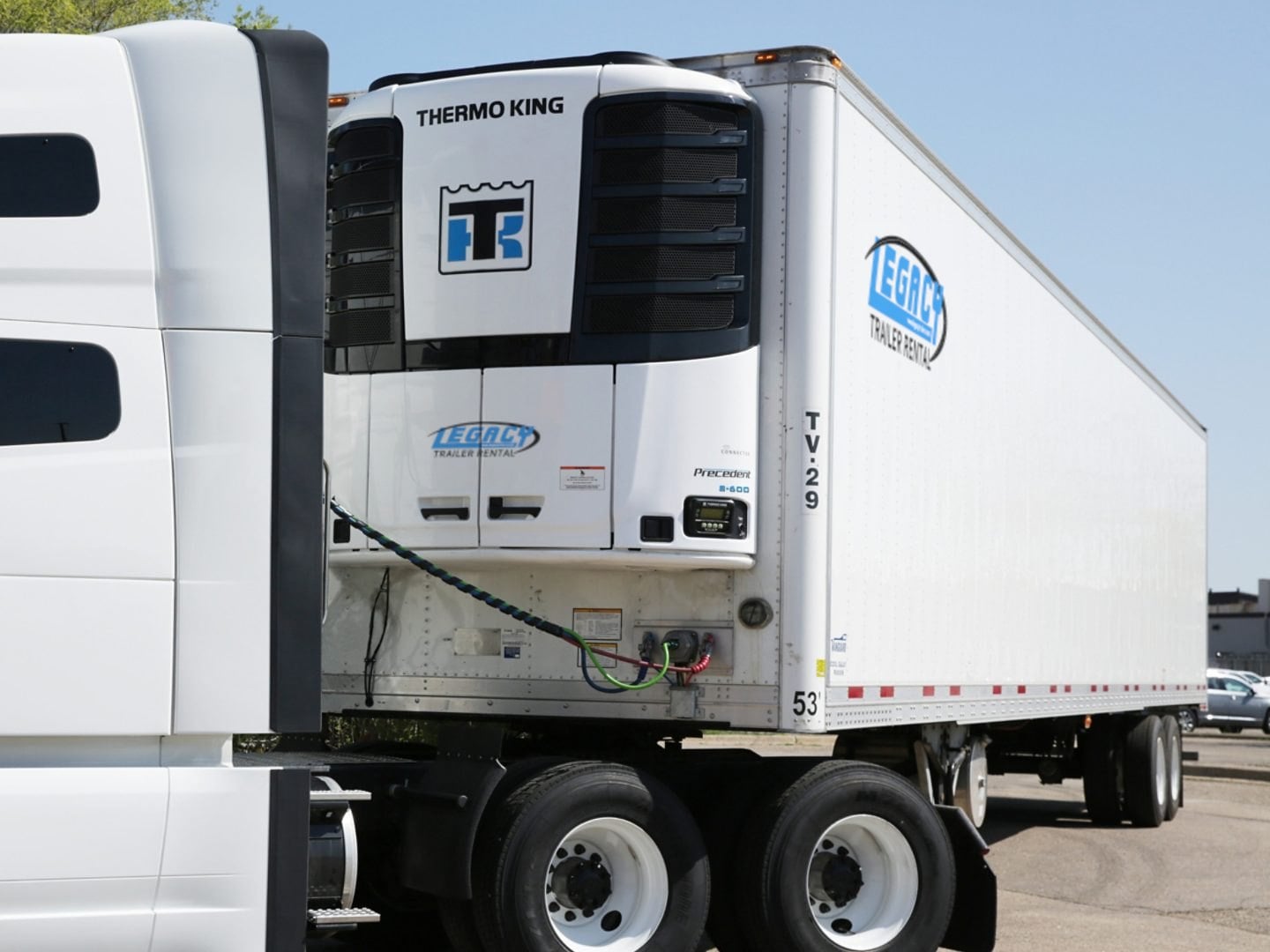 A white reefer trailer with Legacy Trailer Rental logos and a Thermo King Precedent S-600 unit on the nose, hitched to a tractor