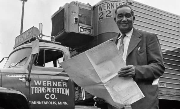 Frederick McKinley Jones holds a large drawing in front of a refrigerated truck