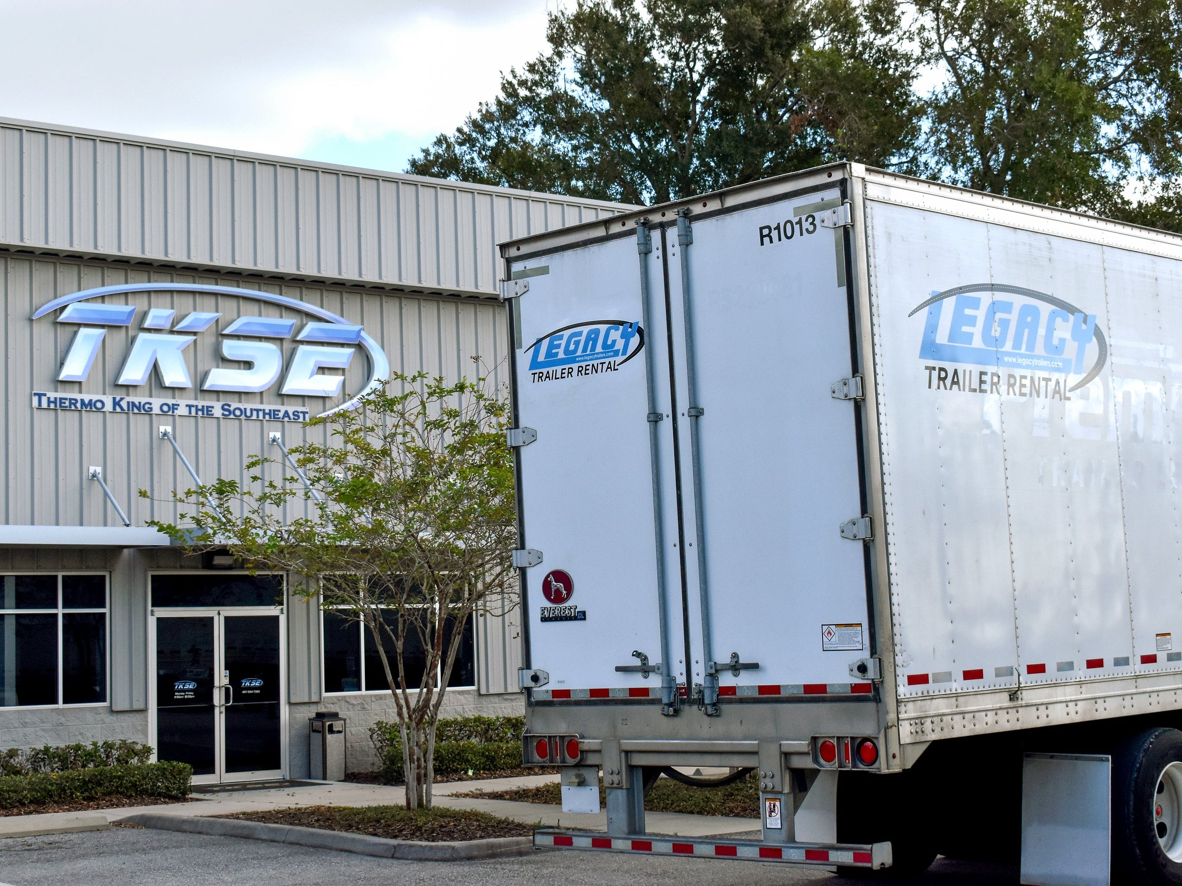 A Legacy Trailer Rental trailer parked outside a TKSE shop