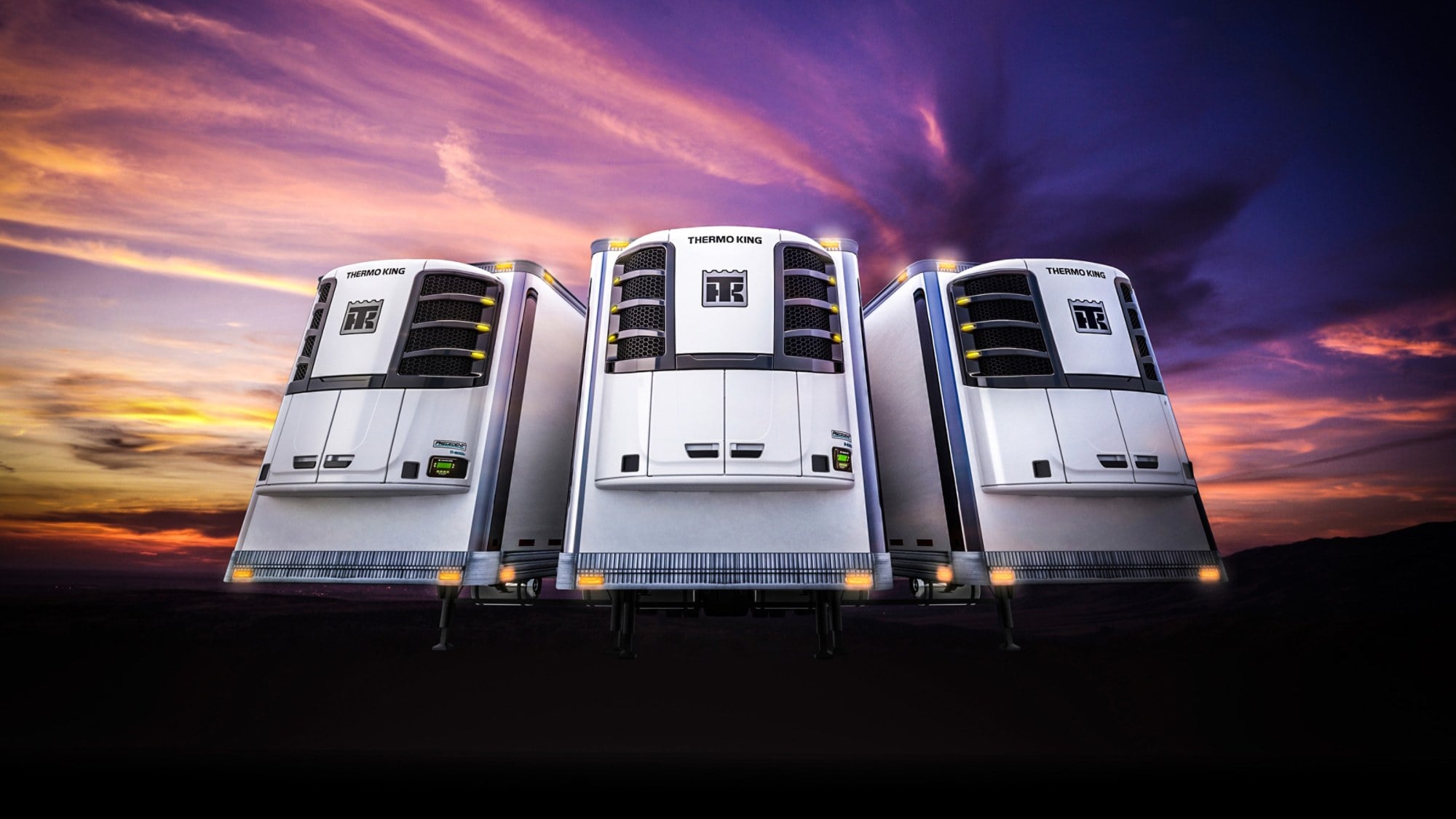 Three Thermo King Precedent trailer units against a dusk sky