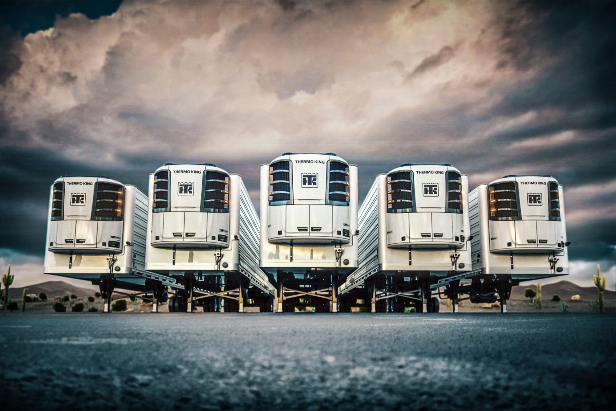 Five Thermo King Precedent trailer units in a row under a stormy sky