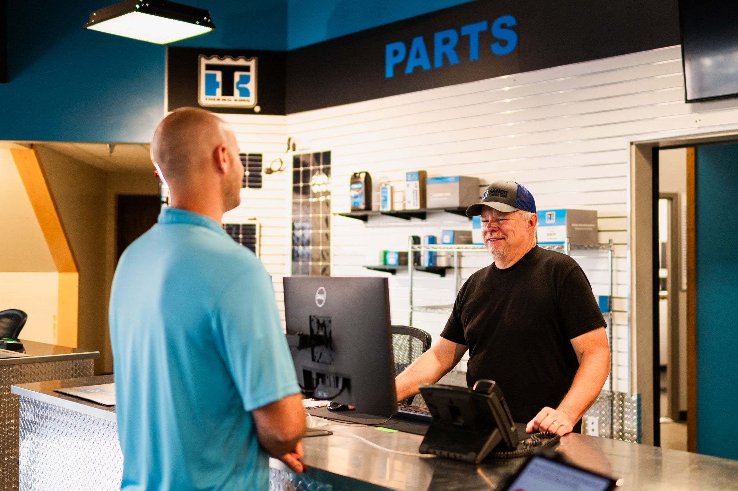 A parts counter manager helping a customer at a Thermo King dealer's parts counter