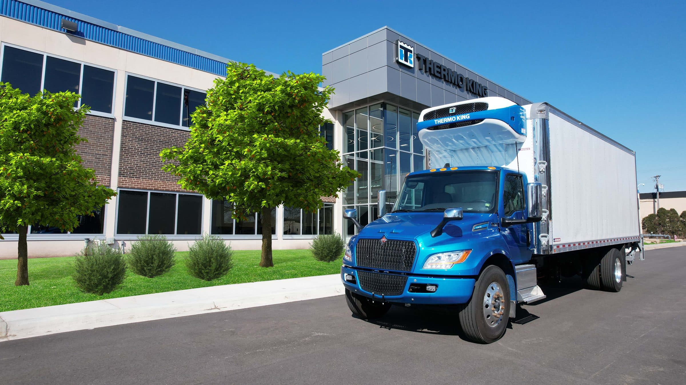 A blue electric box truck with a Thermo King e1000 parked outside Thermo King's headquarters