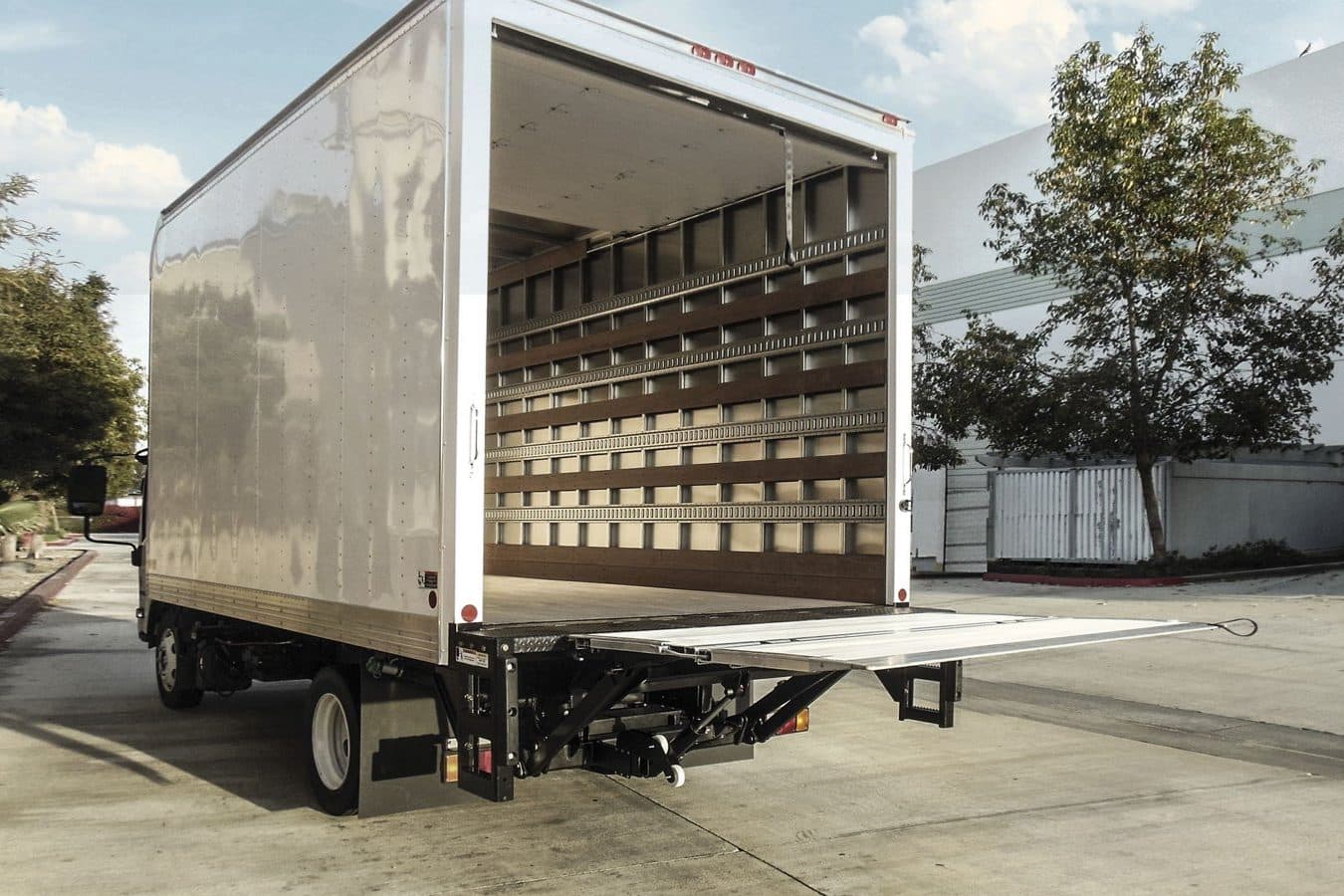 A box truck with its rear doors open and a Palfinger PLR folding liftgate extended flat at bed height