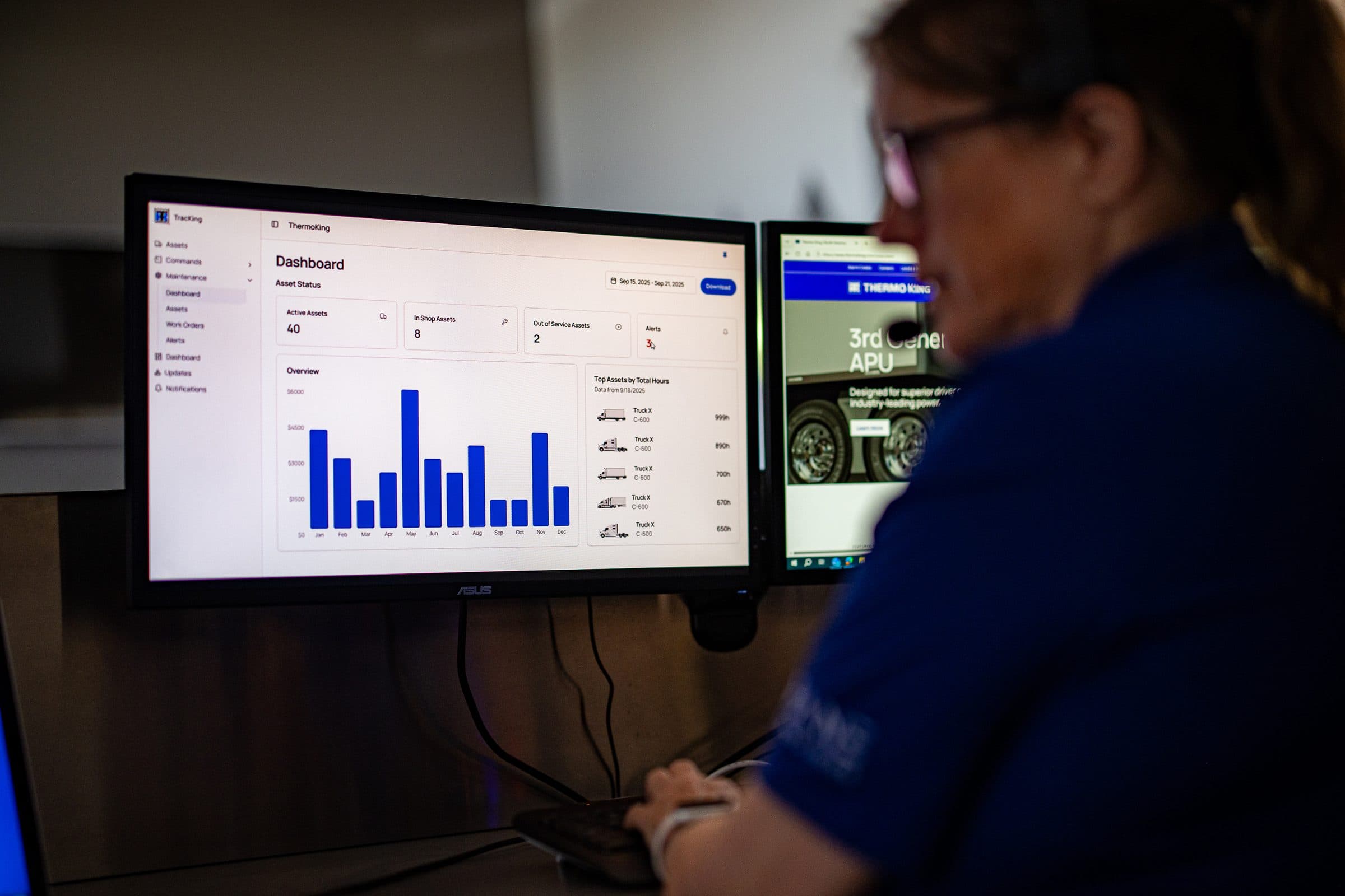 A person wearing a headset watching a telematics dashboard on a monitor