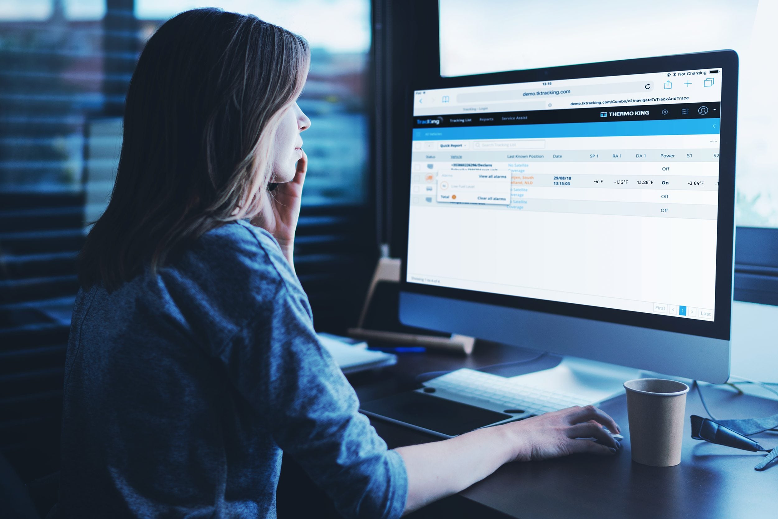 A fleet manager at a monitor showing Thermo King's TracKing web portal