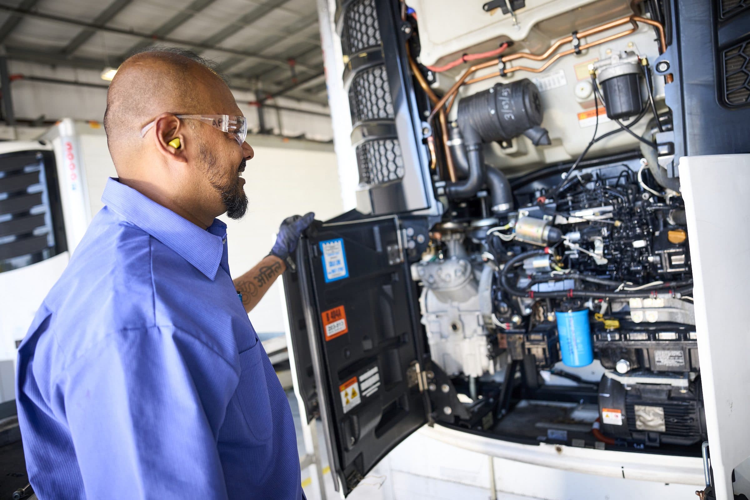 A technician opening the side door of a Thermo King trailer unit