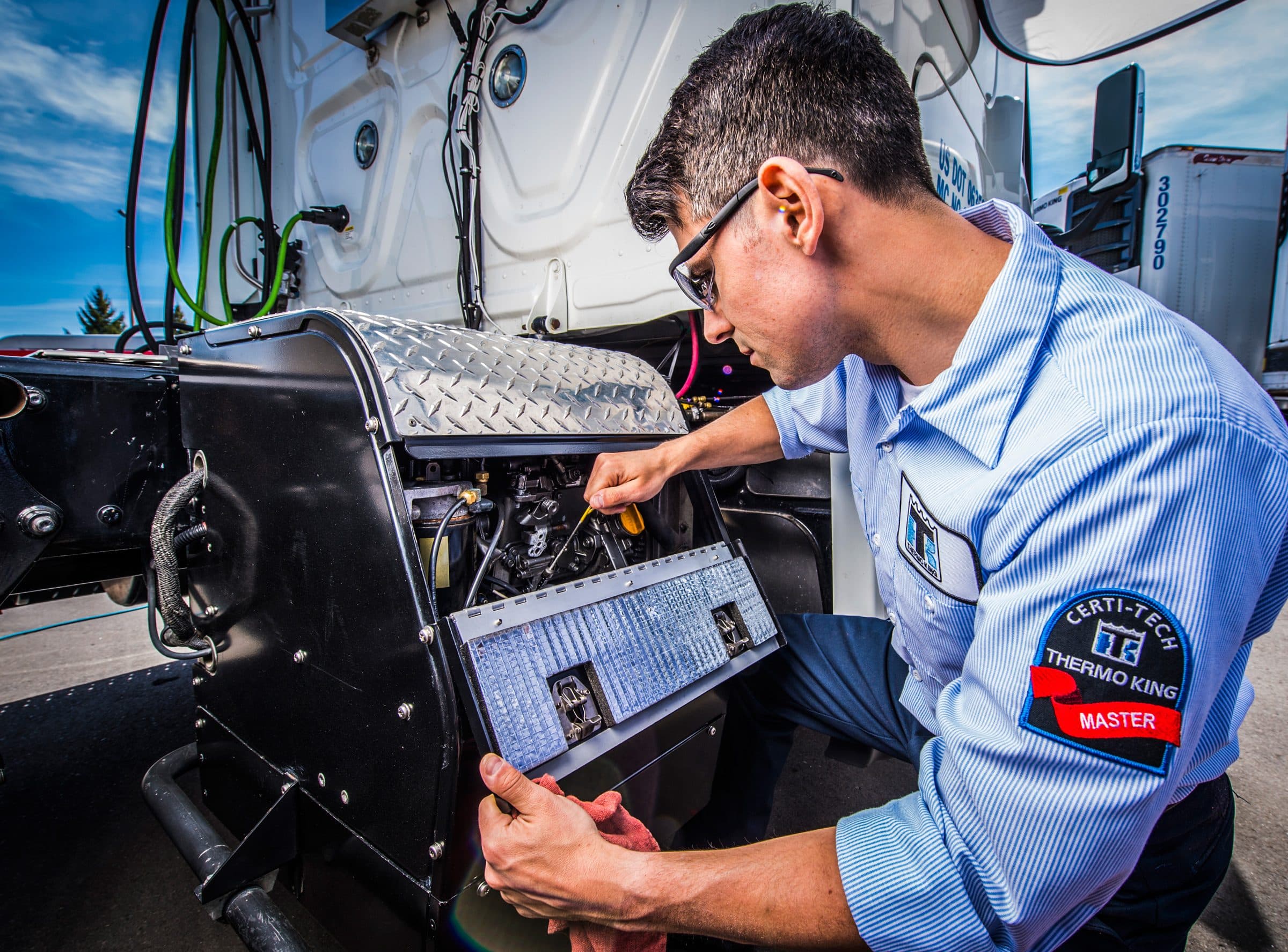 A technician servicing a Thermo King TriPac APU