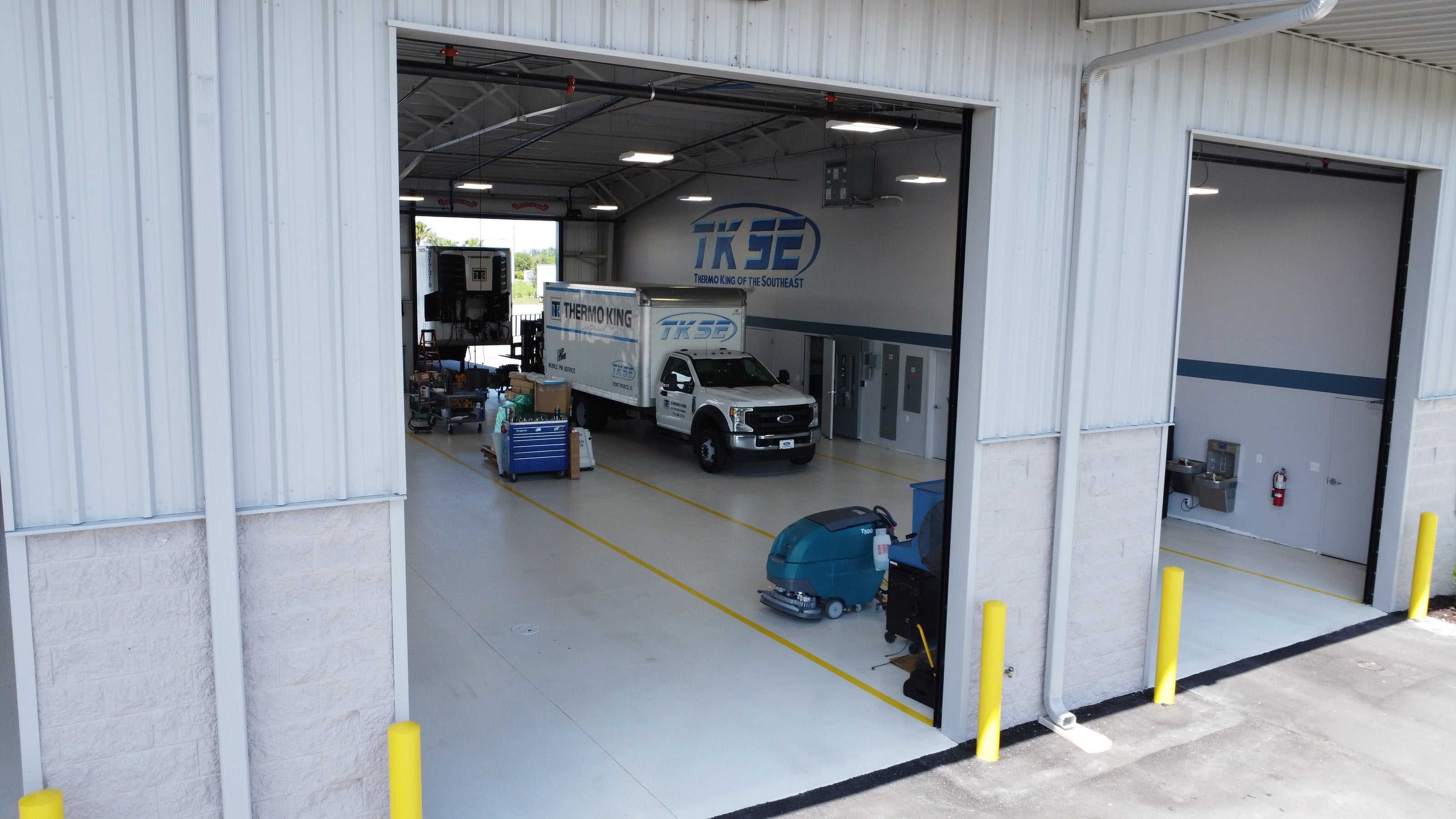 An open service bay at TKSE's Fort Pierce shop, with TKSE service trucks inside